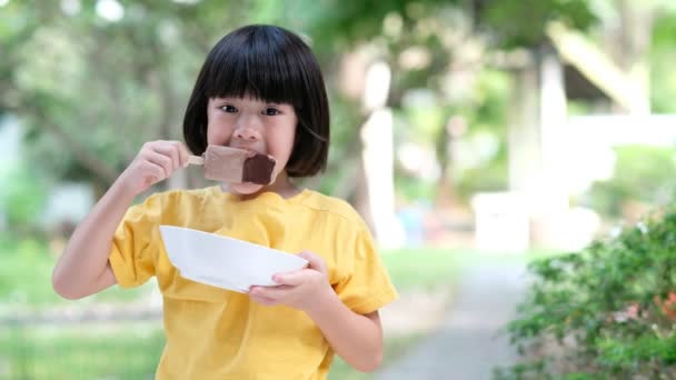 Asiatische Mädchen Essen Eis Mit Unscharfem Hintergrund — Stockvideo