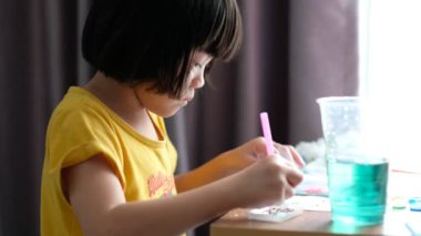 Asyalı çocuk oyuncağa renk katar, eğitim kavramı