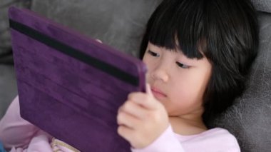 Çinli çocuk bağımlı telefon, akıllı telefon oynayan Asyalı kız, çizgi film izleyen çocuk.