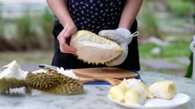 Yakın plan kadın eli soyan Durian, meyvelerin kralı