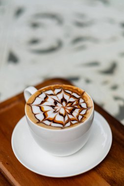 Tahta masada sıcak latte sanat kahvesi, rahatla Tim.