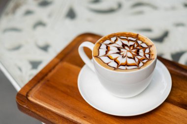 Tahta masada sıcak latte sanat kahvesi, rahatla Tim.