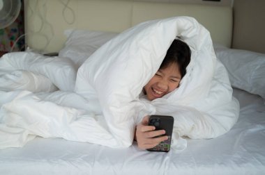 Çocuk yatakta tablet izliyor, çocuk müptelası araba da