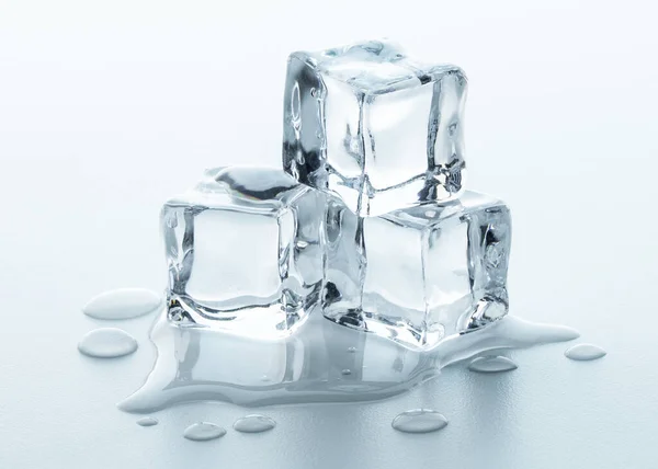 Melting Ice cubes with water drops on a table. Clear ice  in cube shape. Frozen water. Ice maker. Fake or Artificial acrylic or plastic ice cubes.  White light blue background.