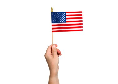 Amerikan Bayrağı adamın elinde. 4 Temmuz Bağımsızlık Günü. Amerikan yıldız çizgili vatanseverlik sembolü. Amerika Birleşik Devletleri. İzole edilmiş beyaz arka planda bayrak. Nesne Makro Yakın çekim Yüksek çözünürlüklü fotoğraf.