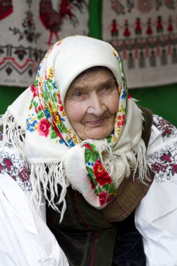Zor bir hayat yaşamış bir yaşlı kadın Ulusal elbiseli portresi.