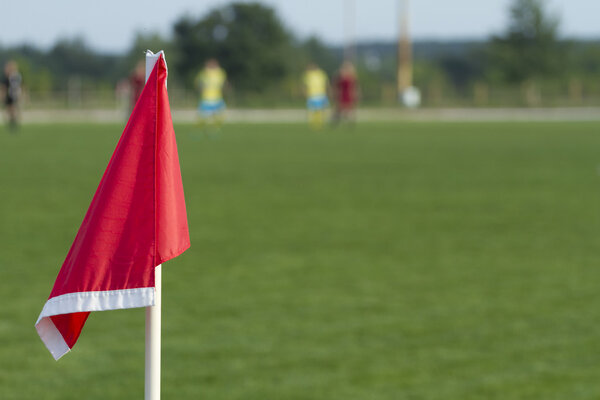 Red corner flag on a soccer field.