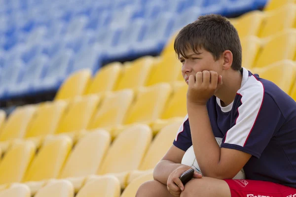 Genç futbolcu oyun durur üzerinden izlerken bir top ile.