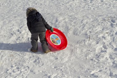Bir plastik tabak bir çocukla bir tepe üzerinde yükselir.