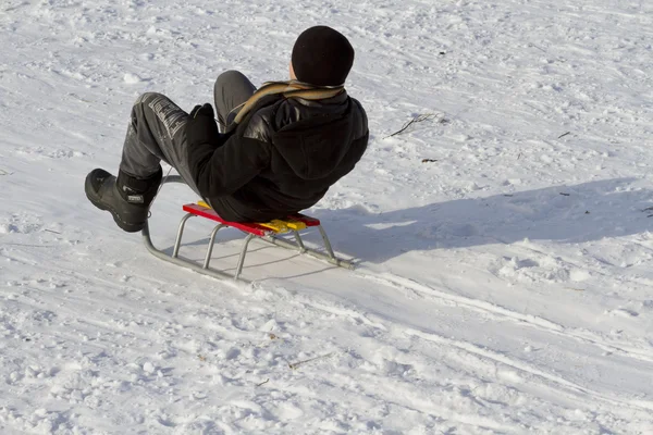 骑着雪橇下山的少年. — 图库照片