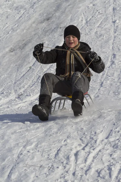 下山在雪橇上的少年. — 图库照片