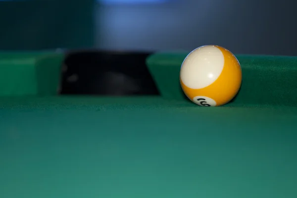 Yellow striped ball at the side of the pool table. — Stock Photo, Image