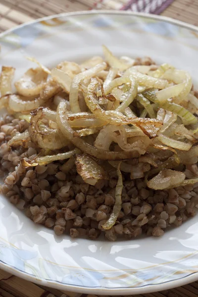 Prato com mingau de trigo mourisco aromatizado com cebola frita . — Fotografia de Stock