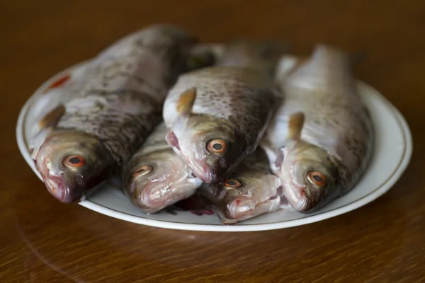 Poisson frais sans écailles dans un bol sur une table en bois . — Photo