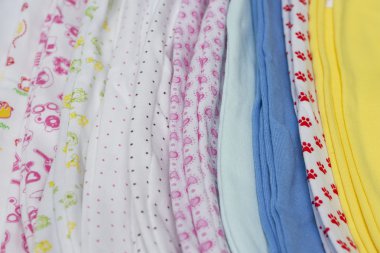 Parlak bebek kıyafetleri üst üste dizilmiş..