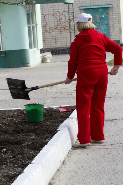 A woman with a shovel. — Stock Photo, Image