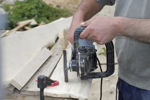 Joiner works with the surface of oak planks.