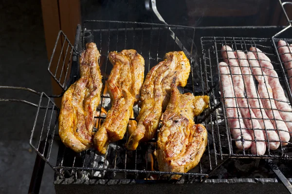 Cooking meat and sausages on the grill. — Stock Photo, Image