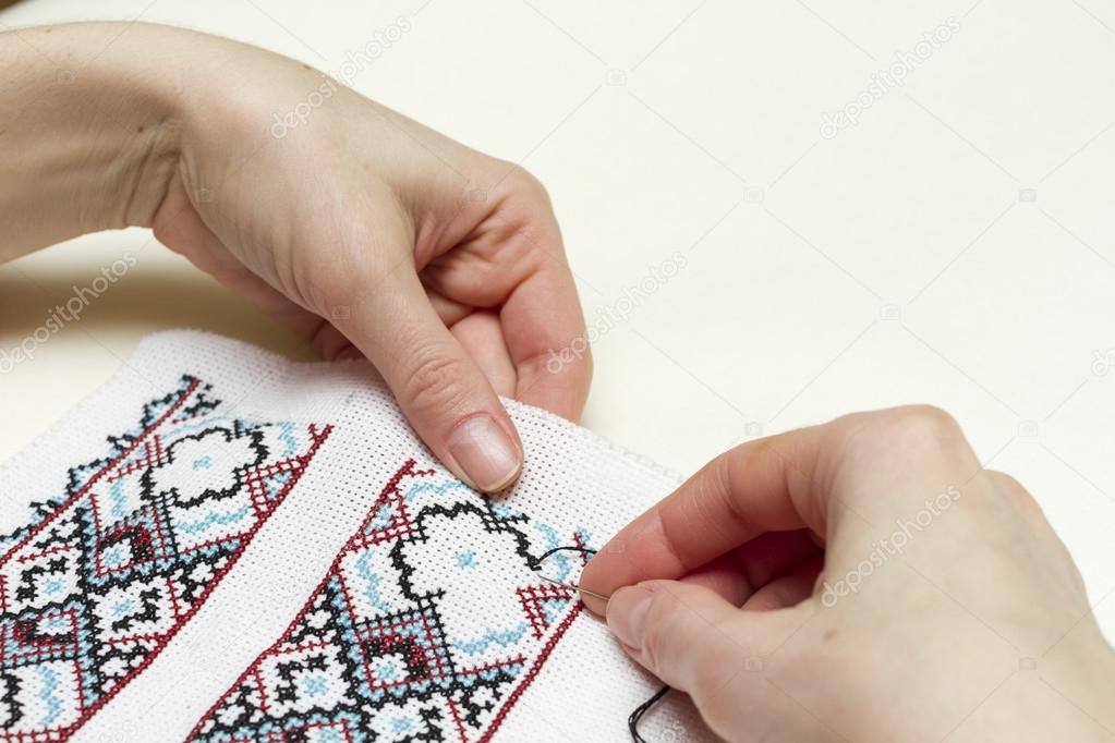 Hands girls embroider pattern cross.