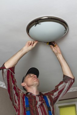 Elektrikçi lamba Oda tavanda aydınlatma yükler.