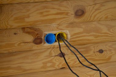 Holes for the electrical outlets in a log house. clipart