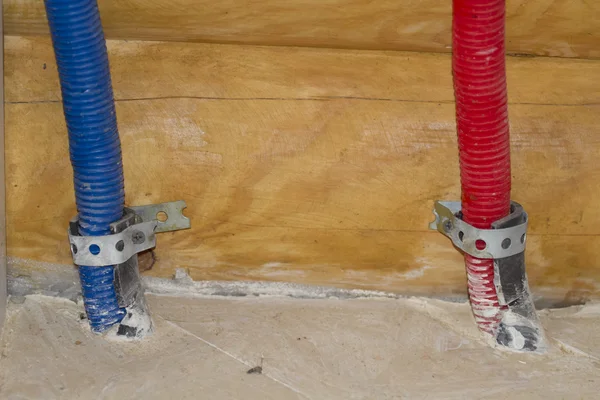 Two tubes underfloor enshrined in the wooden wall. — Stock Photo, Image