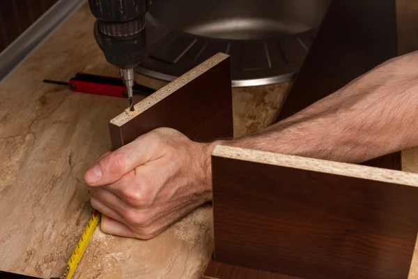 Pièces de meubles pendant le perçage dans les mains du constructeur de meubles . — Photo