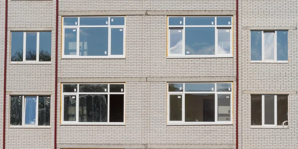 Nueva pared de ladrillo con ventanas de plástico . — Foto de Stock