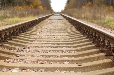 Yakın plan - sonbahar günbatımı raylarda. Sonbahar arkaplanı - demiryolu rayları ufukta kayboluyor.