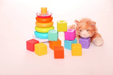 Çocuk oyuncakları, masada renkli plastik tuğlalar. Çocuk halkaları piramidi ve parlak inşaat blokları. Erken öğrenme. Hafif arkaplan. Eğitici oyuncaklar.