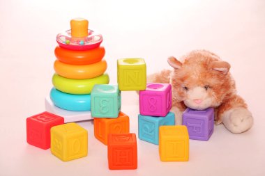 Çocuk oyuncakları, masada renkli plastik tuğlalar. Çocuk halkaları piramidi ve parlak inşaat blokları. Erken öğrenme. Hafif arkaplan. Eğitici oyuncaklar.
