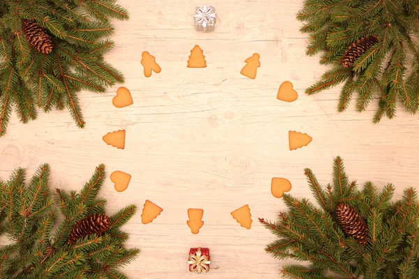 圣诞节和新年背景 带有圆锥的冷杉树枝躺在木制的背景上 上面装饰着圣诞饼干和圣诞球 — 图库照片