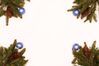 Noel ve Yeni Yıl geçmişi. Kozalaklı dallar, Noel kurabiyeleri ve Noel toplarıyla süslenmiş ahşap bir arka planda yatıyor..