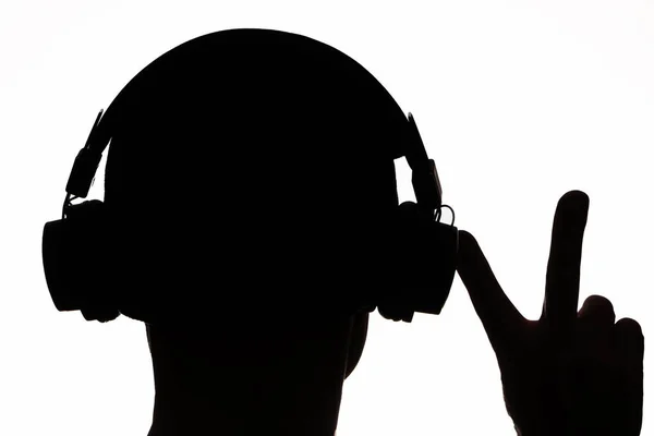 Draadloze Technologie Donker Silhouet Hoofdtelefoon Luistert Naar Muziek Een Witte — Stockfoto