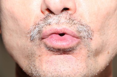 Kırmızı ruj makyajlı erkek dudakları. Erkek, seksi ağız. Kozmetik, moda makyaj konsepti. Tutkulu bir öpücük.