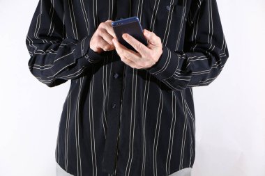 Siyah gömlekli, açık renk pantolonlu, elinde akıllı telefon tutan bir iş adamı. Beyaz çizgili siyah gömlekli ve elinde akıllı telefon olan açık renk pantolonlu bir erkek manken..