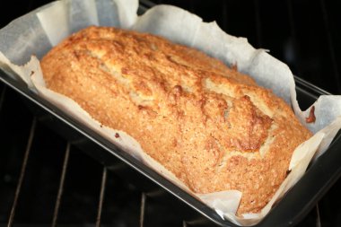 Baked cakes - muffins in the oven on a steel grill on a black background, close-up. The concept of the process of baking and cooking breakfast.