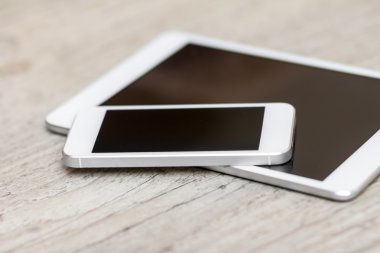 smartphone and tablet on the gray wooden background 