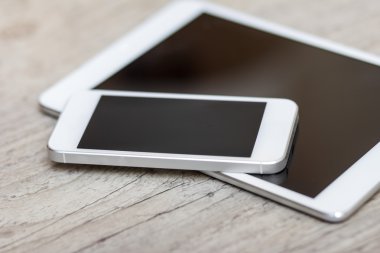 smartphone and tablet on the gray wooden background 