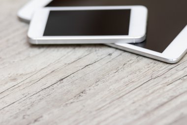 smartphone and tablet on the gray wooden background 