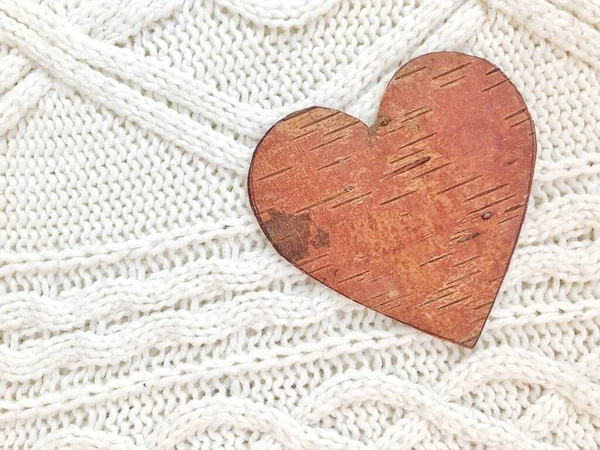 Creative wooden heart on a light sweater. New Years concept. Top wiew