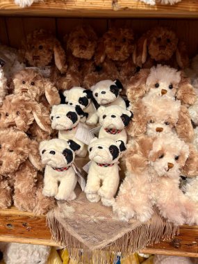 Oyuncak bir butiğin ahşap rafında şirin pelüş köpek ve buldog koleksiyonu..