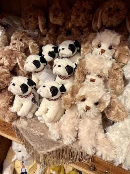 Oyuncak bir butiğin ahşap rafında şirin pelüş köpek ve buldog koleksiyonu..