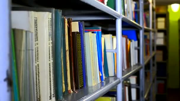 Estantería con libros en una biblioteca — Vídeos de Stock