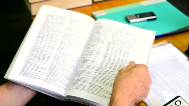 Hands flicking through a dictionary — Stock Video