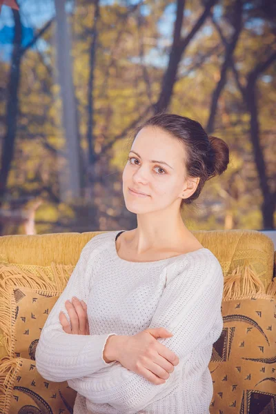 The girl in a white blouse sits on a yellow chair — Stock Photo, Image