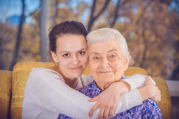 A young girl and an elderly grandmother. Girl hugging her grandm