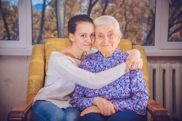 Una ragazza e una nonna anziana. Ragazza che abbraccia la nonna — Foto Stock
