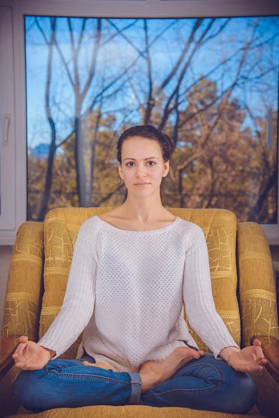 The girl in a white blouse sits on a yellow chair — Stock Photo, Image