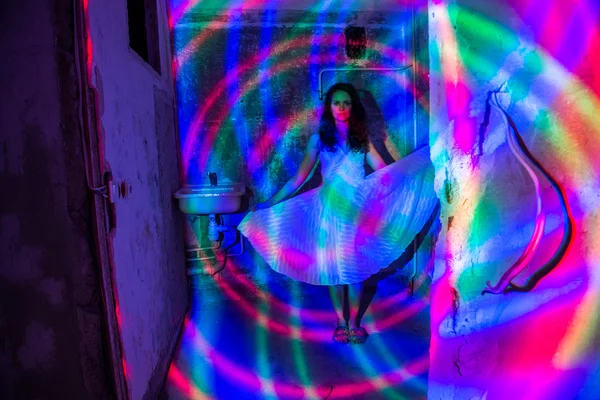 Meisje in gekleurd licht. Oude verlaten appartement. — Stockfoto